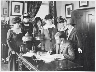 Governor Carl Elias Milliken Signing the Suffrage Bill as Six Women Look On by American Photographer
